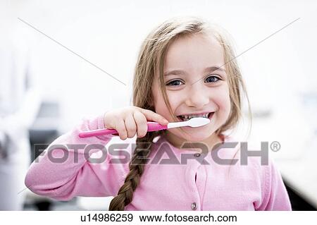 Stock Photo - Girl brushing teeth. Fotosearch