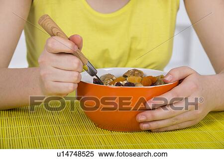Stock Photography - Girl eating bowl of breakfast cereal. Fotosearch