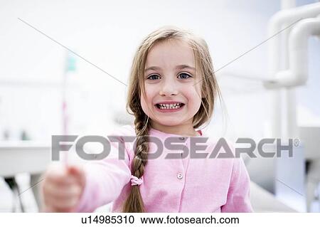 Stock Image - Girl holding toothbrush. Fotosearch