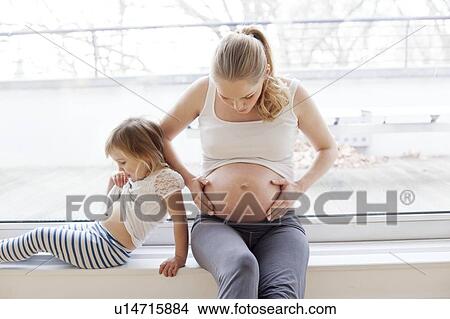 Picture - Girl with pregnant mother. Fotosearch