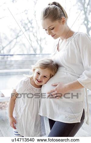 Stock Image - Girl with pregnant mother. Fotosearch