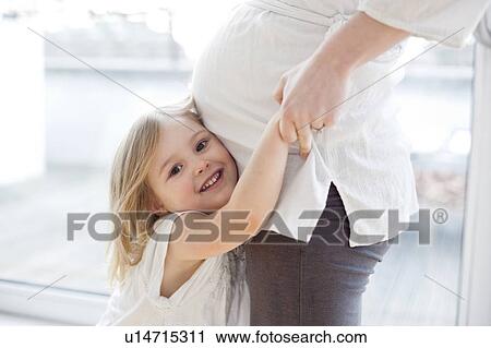 Stock Image - Girl with pregnant mother. Fotosearch