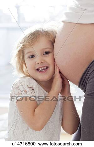Stock Image - Girl with pregnant mother. Fotosearch