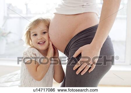 Stock Photograph - Girl with pregnant mother. Fotosearch