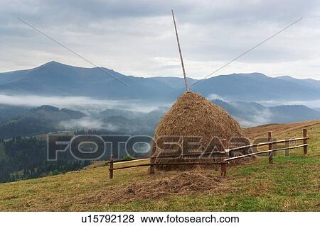 Stock Photo - Haystack on field in mountains. Fotosearch
