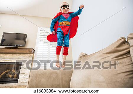 Little boy (2-3) in superman costume jumping on sofa View Large Photo Image Picture - Little boy (2-3) in superman costume jumping on sofa. Fotosearch
