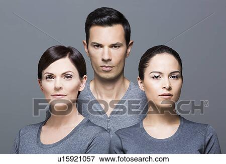 Stock Photo - Man and two women wearing grey tops. Fotosearch