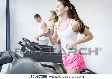 Stock Photography - Man and woman exercising in gym. Fotosearch