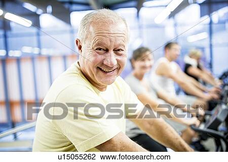 Stock Image - Man exercising stationary bicycle. Fotosearch