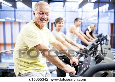 Stock Image - Man exercising stationary bicycle. Fotosearch