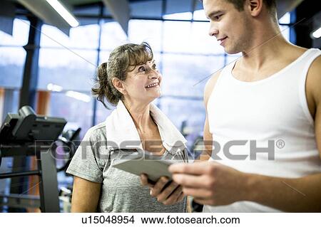 Man holding tablet with senior woman View Large Photo Image Picture - Man holding tablet with senior woman. Fotosearch