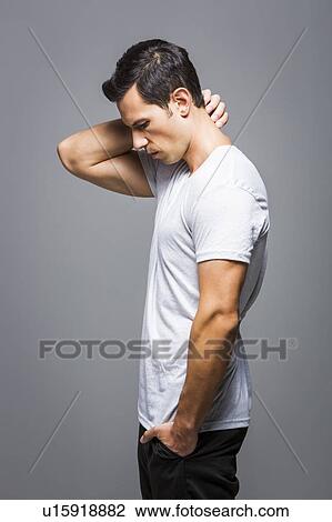 Stock Image - Man in white t-shirt on grey background. Fotosearch