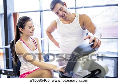 Man instructing woman in gym View Large Photo Image Stock Photography - Man instructing woman in gym. Fotosearch