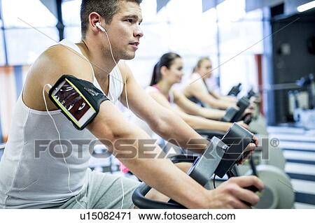 Stock Image - Man listening to music in gym. Fotosearch