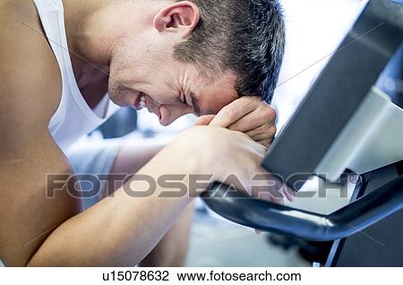 Man resting his head on exercise machine View Large Photo Image Stock Image - Man resting his head on exercise machine. Fotosearch