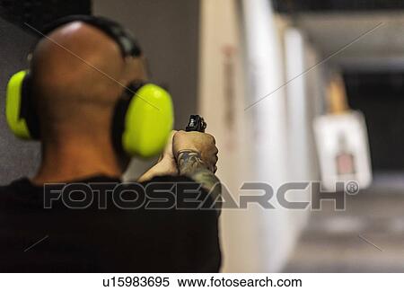 Man shooting gun at shooting range View Large Photo Image Stock Photography - Man shooting gun at shooting range. Fotosearch