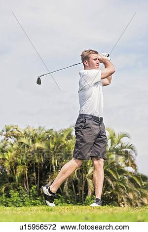 Stock Image - Man swinging golf club. Fotosearch