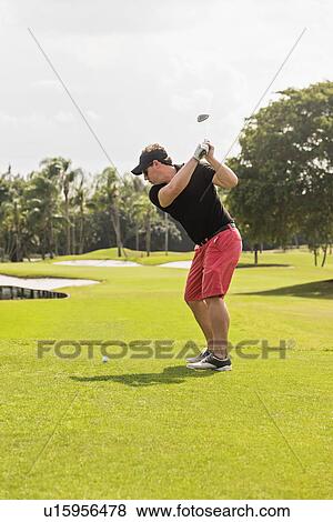 Man swinging golf club View Large Photo Image Stock Photo - Man swinging golf club. Fotosearch