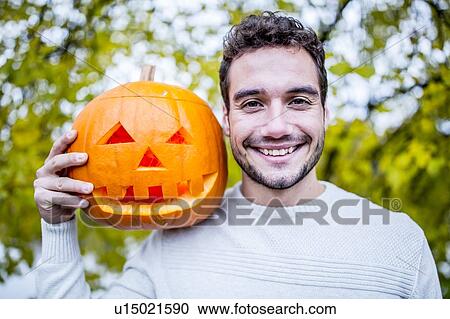 Stock Image - Man with Halloween pumpkin. Fotosearch
