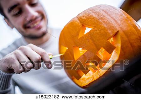 Stock Image - Man with Halloween pumpkin. Fotosearch