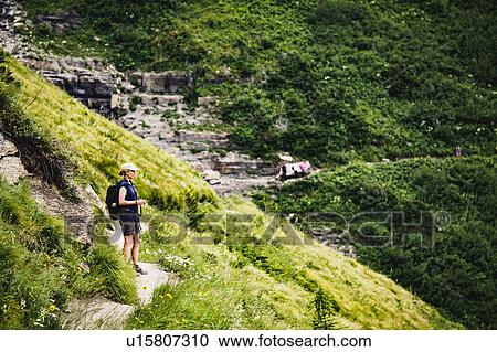 Mature woman standing on path in mountains View Large Photo Image Stock Image - Mature woman standing on path in mountains. Fotosearch