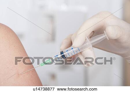 Stock Photo - Medical worker injecting patient. Fotosearch
