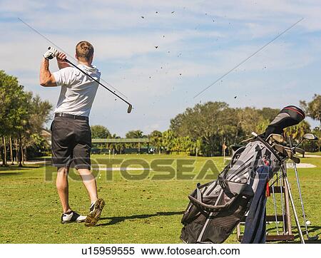 Stock Photography - Mid adult man playing golf. Fotosearch