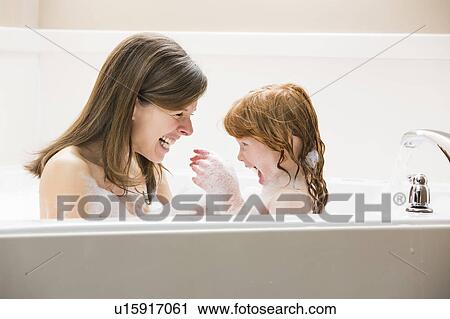 Stock Image - Mother and daughter (4-5) having bubble bath. Fotosearch