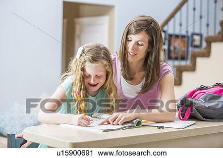 Mother and daughter (8-9) sitting at table doing homework View Large Photo Image Stock Image - Mother and daughter (8-9) sitting at table doing homework. Fotosearch