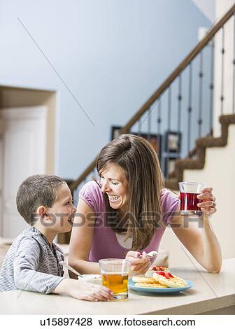 Mother and son (6-7) eating breakfast View Large Photo Image Stock Photo - Mother and son (6-7) eating breakfast. Fotosearch