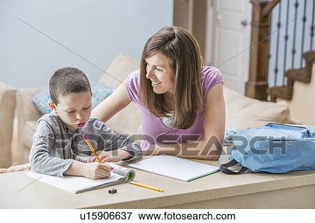 Mother helping son (6-7) doing homework View Large Photo Image Stock Photo - Mother helping son (6-7) doing homework. Fotosearch