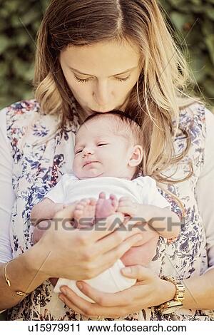Mother holding and kissing daughter (2-5 months) View Large Photo Image Stock Image - Mother holding and kissing daughter (2-5 months). Fotosearch