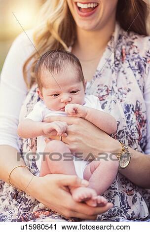 Stock Image - Mother holding daughter (2-5 months). Fotosearch