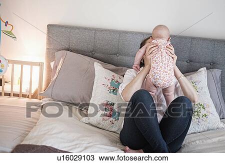 Mother playing with baby daughter (2-5 months) in bedroom View Large Photo Image Stock Image - Mother playing with baby daughter (2-5 months) in bedroom. Fotosearch
