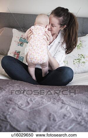 Mother playing with baby daughter (2-5 months) in bedroom View Large Photo Image Stock Image - Mother playing with baby daughter (2-5 months) in bedroom. Fotosearch