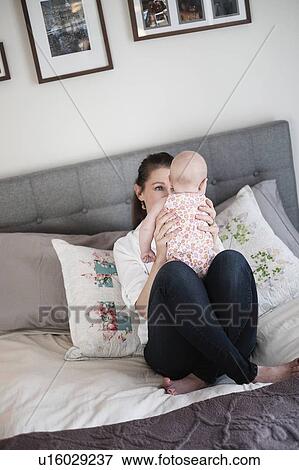 Mother playing with baby daughter (2-5 months) in bedroom View Large Photo Image Stock Photo - Mother playing with baby daughter (2-5 months) in bedroom. Fotosearch