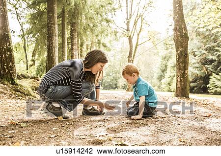 Stock Image - Mother playing with son (2-3) in park. Fotosearch