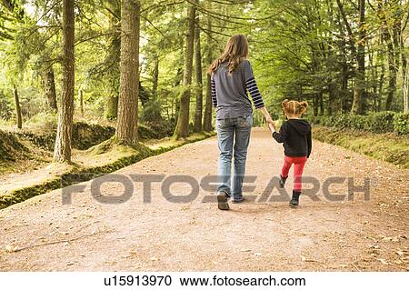 Stock Image - Mother walking with daughter (4-5) in park. Fotosearch