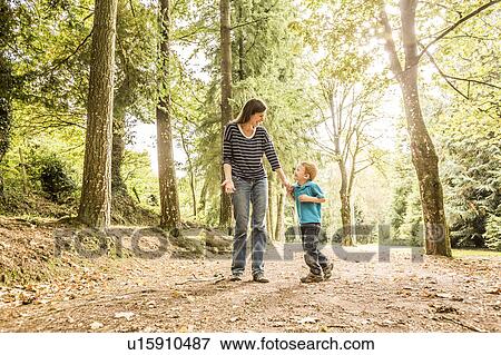 Stock Photo - Mother walking with son (2-3) in park. Fotosearch