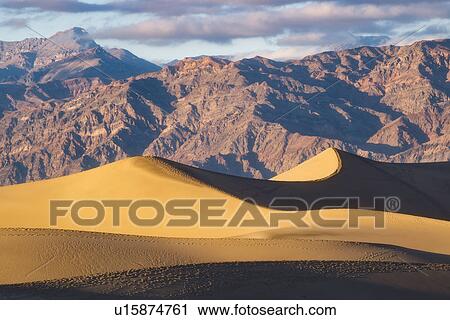 Stock Image - Mountain range with sand dunes in foreground. Fotosearch