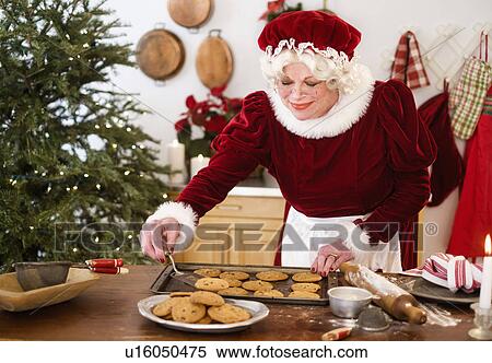 Stock Photography - Mrs. Claus making gingerbread cookies. Fotosearch