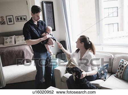 Parents playing with baby daughter (2-5 months) and dog in living room View Large Photo Image Stock Image - Parents playing with baby daughter (2-5 months) and dog in living room. Fotosearch