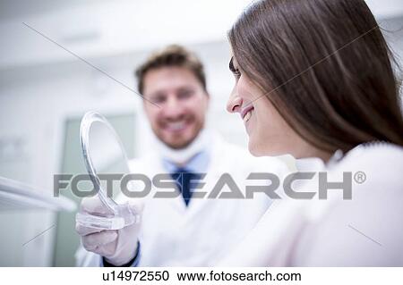 Stock Image - Patient looking in mirror. Fotosearch