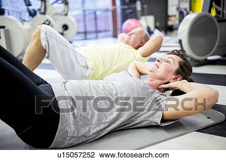 Stock Image - People exercising in gym. Fotosearch