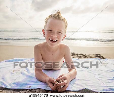 Portrait of boy (6-7) and girl (4-5) lying on beach laughing View Large Photo Image Stock Photograph - Portrait of boy (6-7) and girl (4-5) lying on beach laughing. Fotosearch