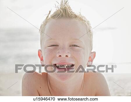 Stock Image - Portrait of boy (6-7) on beach. Fotosearch