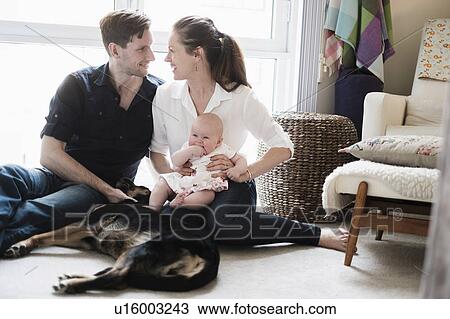 Portrait of happy family sitting on carpet with daughter (2-5 months) and dog View Large Photo Image Stock Image - Portrait of happy family sitting on carpet with daughter (2-5 months) and dog. Fotosearch