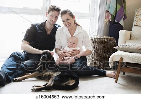 Portrait of happy family sitting on carpet with daughter (2-5 months) and dog View Large Photo Image Stock Image - Portrait of happy family sitting on carpet with daughter (2-5 months) and dog. Fotosearch