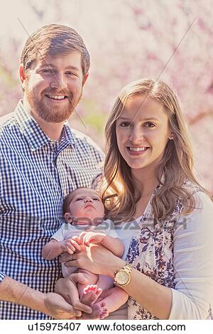 Portrait of happy family with baby girl (2-5 months) View Large Photo Image Stock Photo - Portrait of happy family with baby girl (2-5 months). Fotosearch