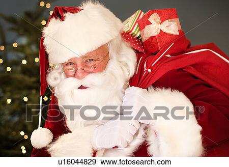 Portrait of Santa Claus carrying sack over shoulder View Large Photo Image Stock Photo - Portrait of Santa Claus carrying sack over shoulder. Fotosearch